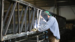 工場で鉄骨を溶接する作業者