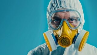 防護服と防毒マスクを着用した作業者